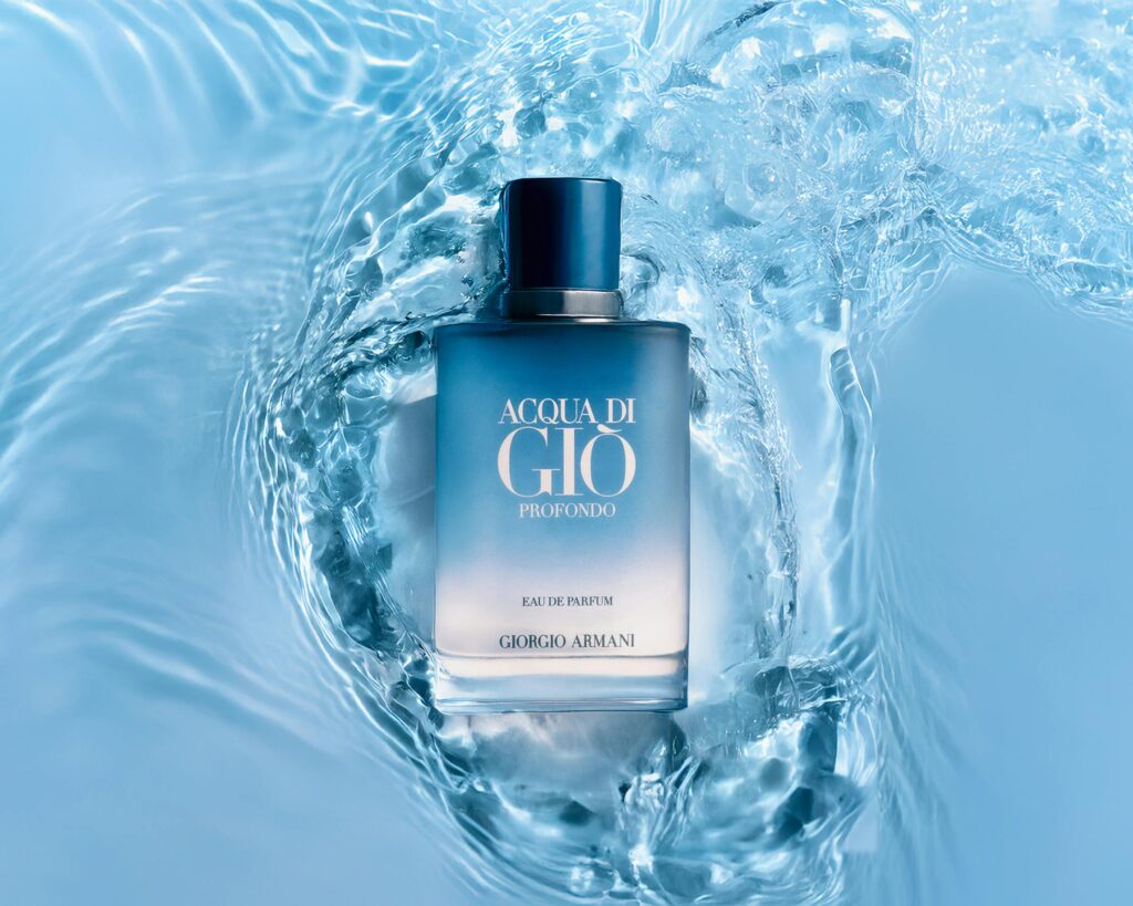 A stylish perfume bottle submerged in calming blue water, evoking freshness and elegance.